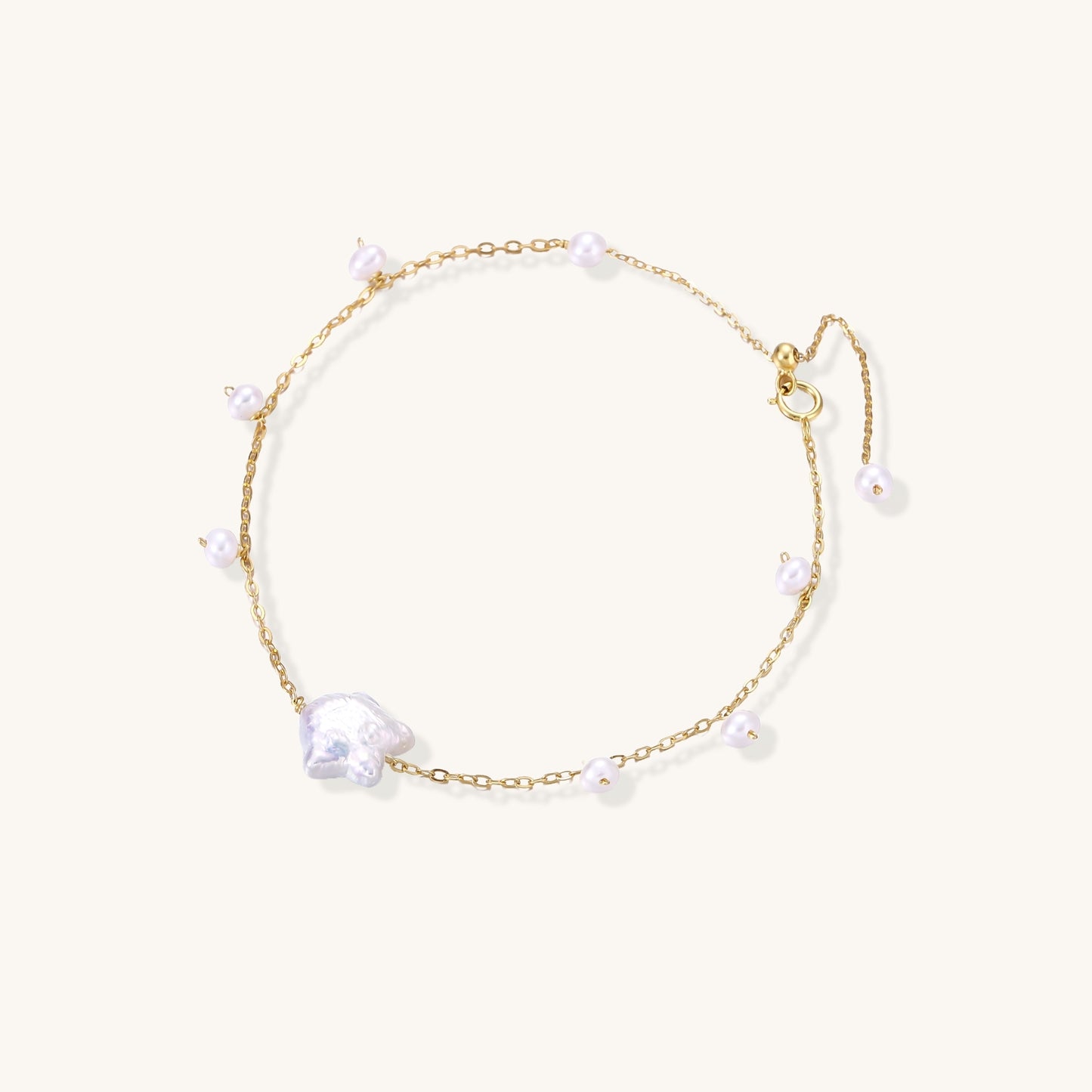 Delicate 18K gold-plated silver chain bracelet with freshwater and baroque pearls on cream background