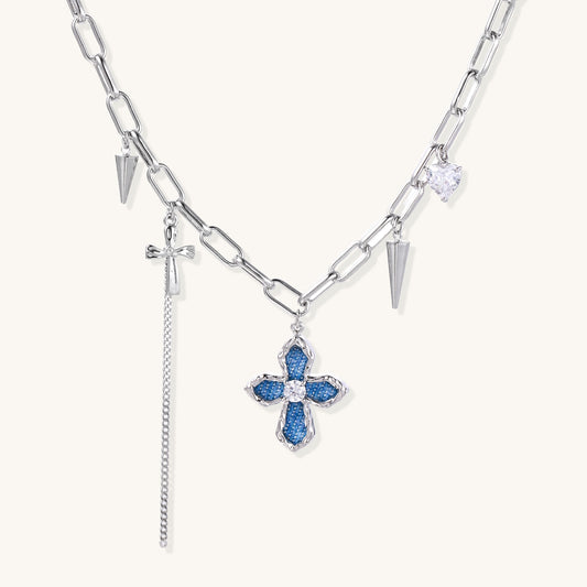 18K gold plated brass chain necklace featuring blue cross pendant with zirconia center stone and spike charms on white background.
